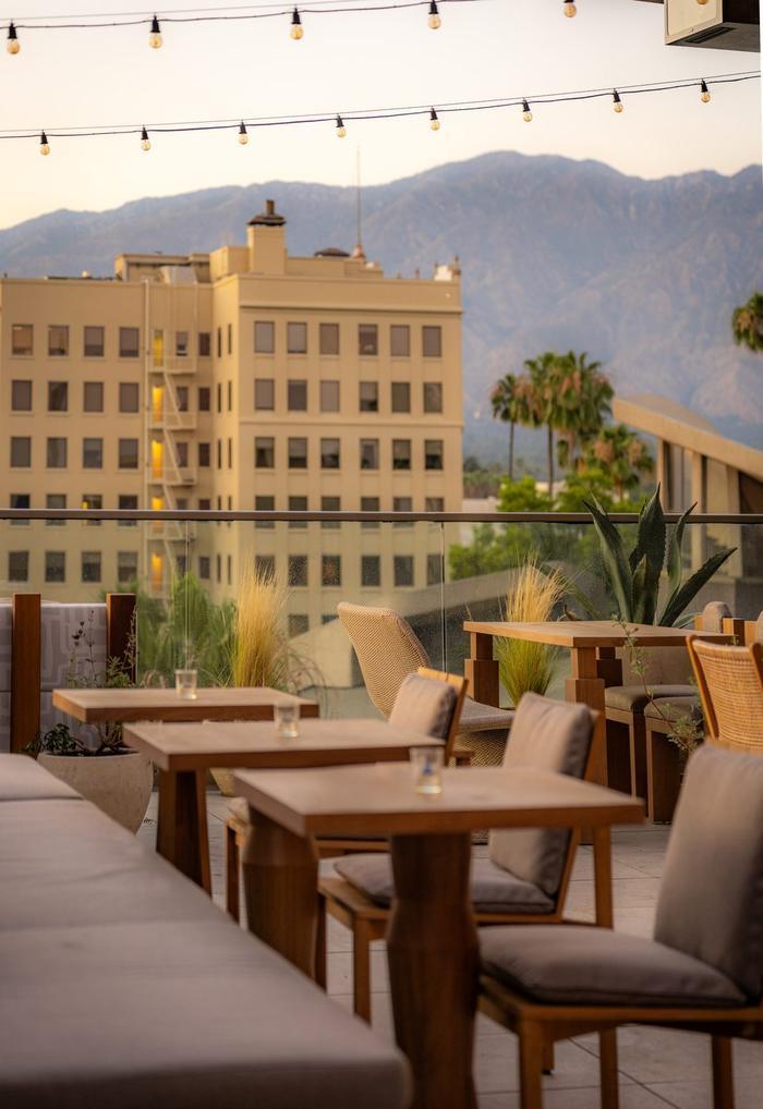 A rooftop bar with the mountains behind