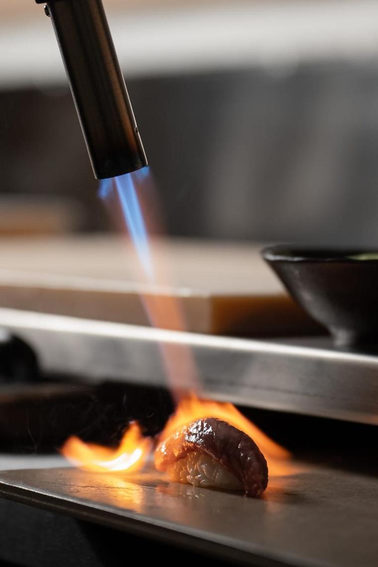 A chef torching nigiri